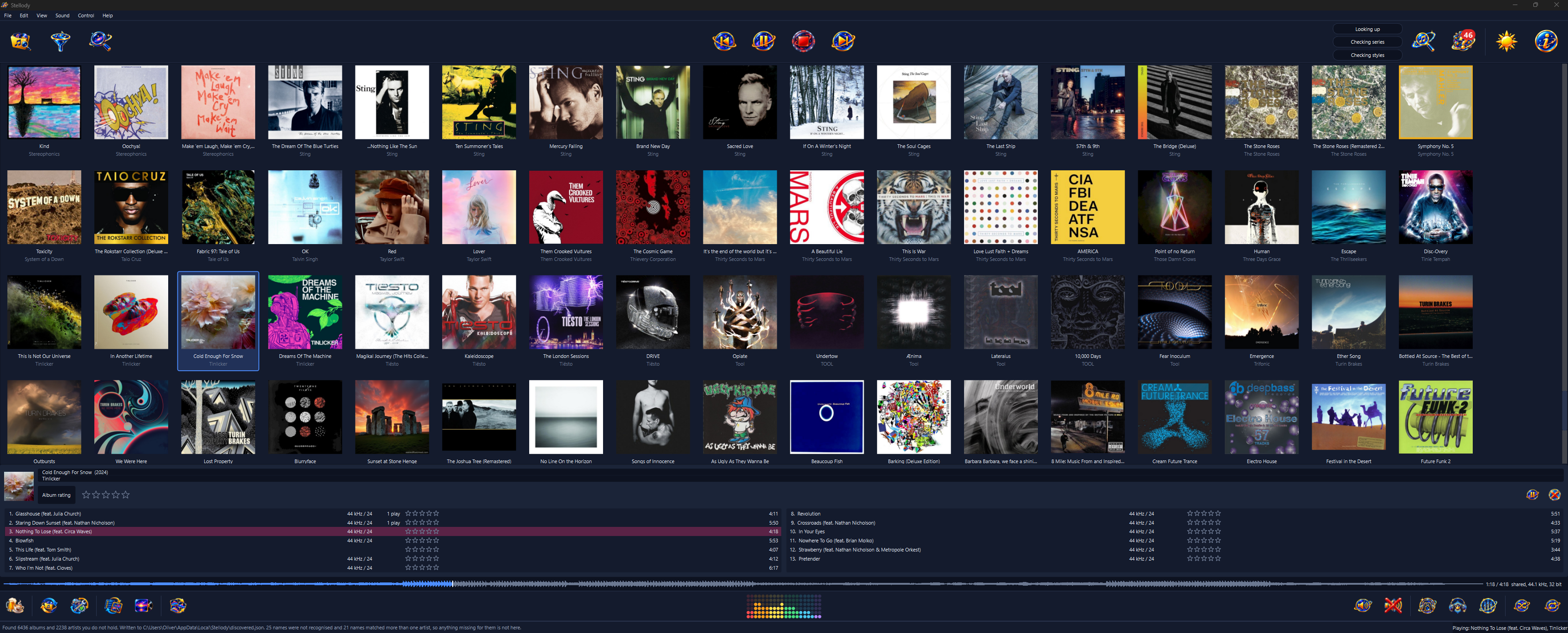 Stellody in its dark appearance, showing the collection as a grid of album sleeves in four rows. Tinlicker's Cold Enough For Snow is picked out and opened in a pane beneath the grid: its cover, its title and its year above an album rating with no stars set, then its thirteen tracks laid out in two columns, each with its rate and depth, its play count where it has one, a row of rating stars and a length. Nothing To Lose (feat. Circa Waves), the third track and the one playing, is marked on its row in the pane; the foot of the window reads Playing: Nothing To Lose (feat. Circa Waves), Tinlicker at its right. At its left is the sentence the last discovery search ended with: it found 6436 albums and 2238 artists the library does not hold, 25 names were not recognised and 21 matched more than one artist. The menu bar reads File, Edit, View, Sound, Control and Help. The play controls sit in the middle of the tray along the top, with the three discovery bars at rest to the right of them, labelled Looking up, Checking series and Checking styles. Then comes the discovery button and beside it the button for the artists that search could not answer for, wearing a red badge reading 46; a rule then separates them from the appearance toggle and Help, which end the tray. The waveform of the playing track runs along the bottom with a line marking how far it has reached; beside it the time reads 1:18 of 4:18, then what the sound device took: shared, 44.1 kHz, 32 bit. The strip below starts with the donate button, then rescan and repair, the two view buttons and the button choosing the visualiser's style. The visualiser sits in the middle of the strip, drawn as its dot matrix. Volume and mute, then the output device, exclusive output and the equalizer, then shuffle and repeat end the strip at the right.